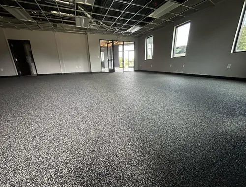 Commercial interior space finished with dark speckled rubber flooring