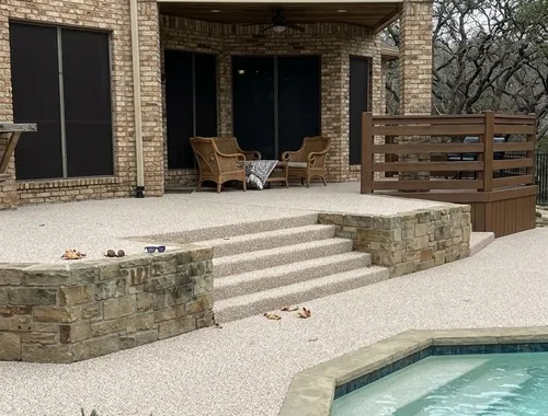 Multi-level pool deck and steps finished with tan TPV rubber surfacing